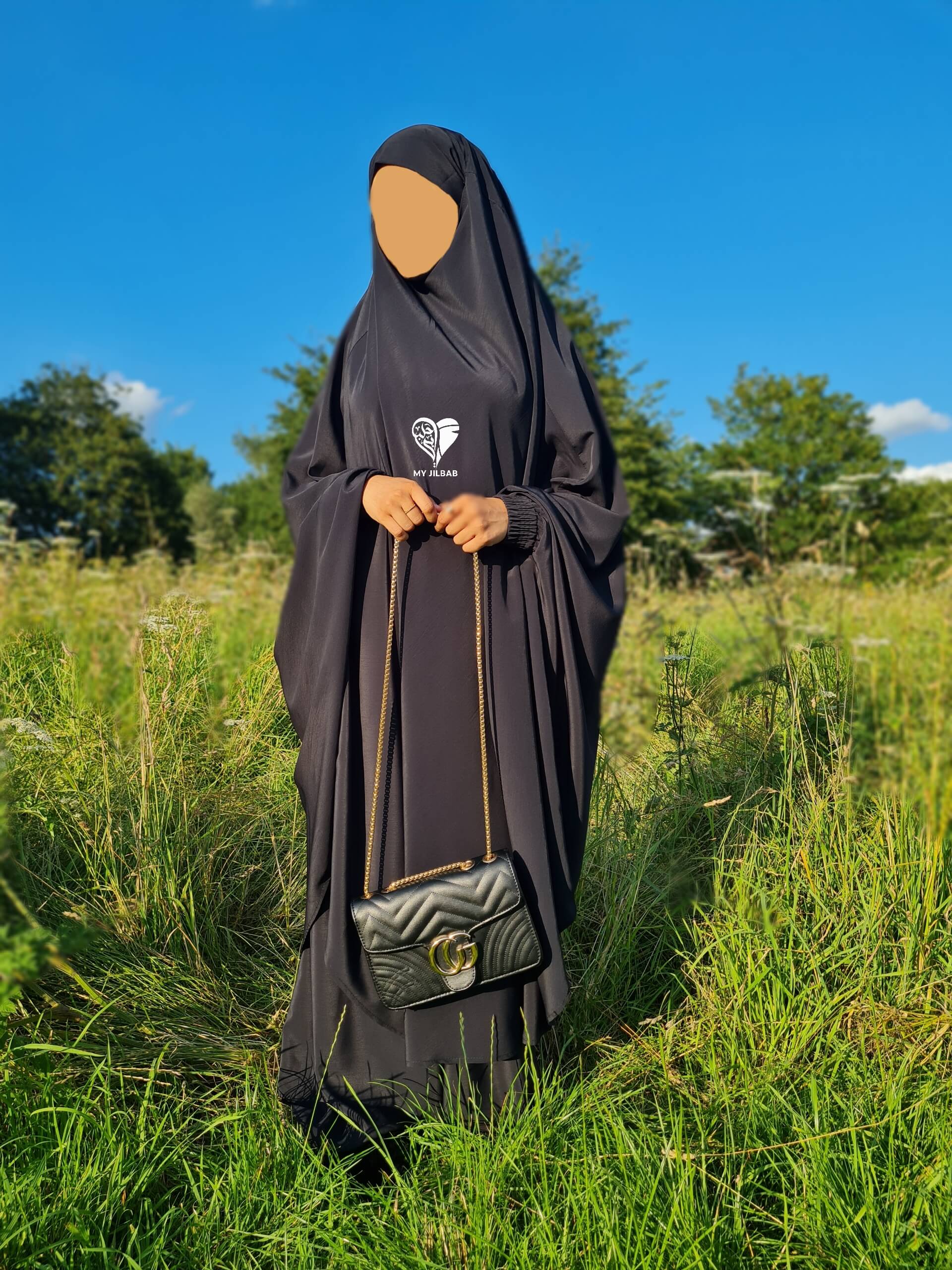 black sheen jilbab with black handbag frontview