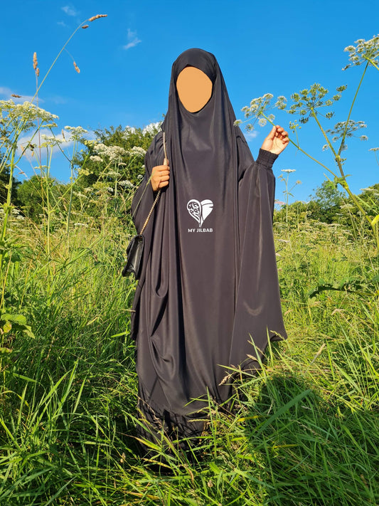 Black sheen jilbab outside on sunny day